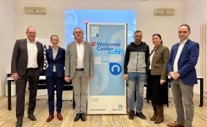 Sechs Personen stehen vor einem Rollup-Banner des Welcome Centers Region Hannover in einem hellen Veranstaltungsraum.