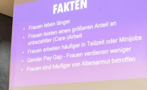 Präsentation „FAKTEN" auf lila Folie mit deutschen Bullet Points zu Frauen: Lebenserwartung, Care-Arbeit, Teilzeit, Gender Pay Gap, Altersarmut.